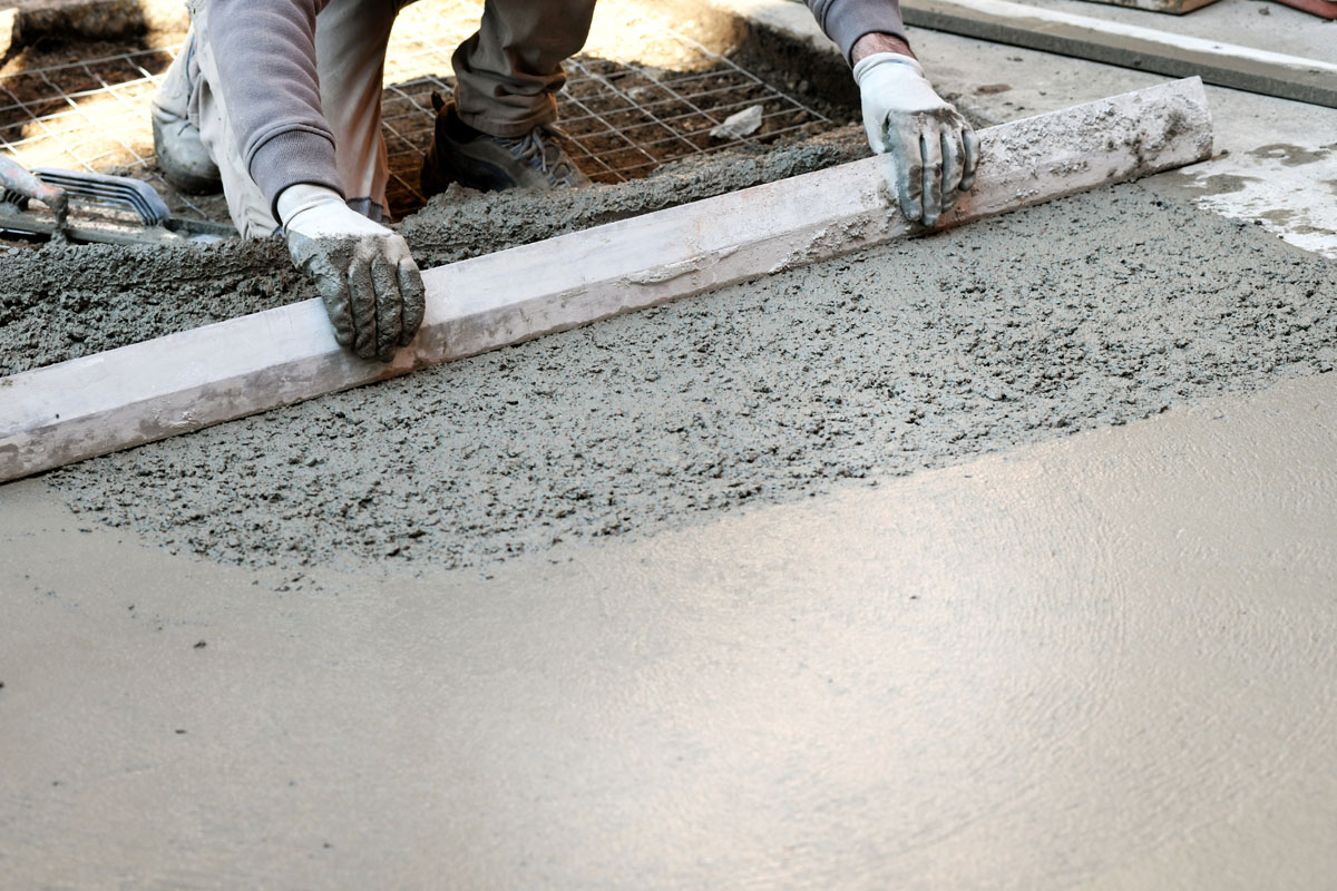 Worker flattening concrete floor